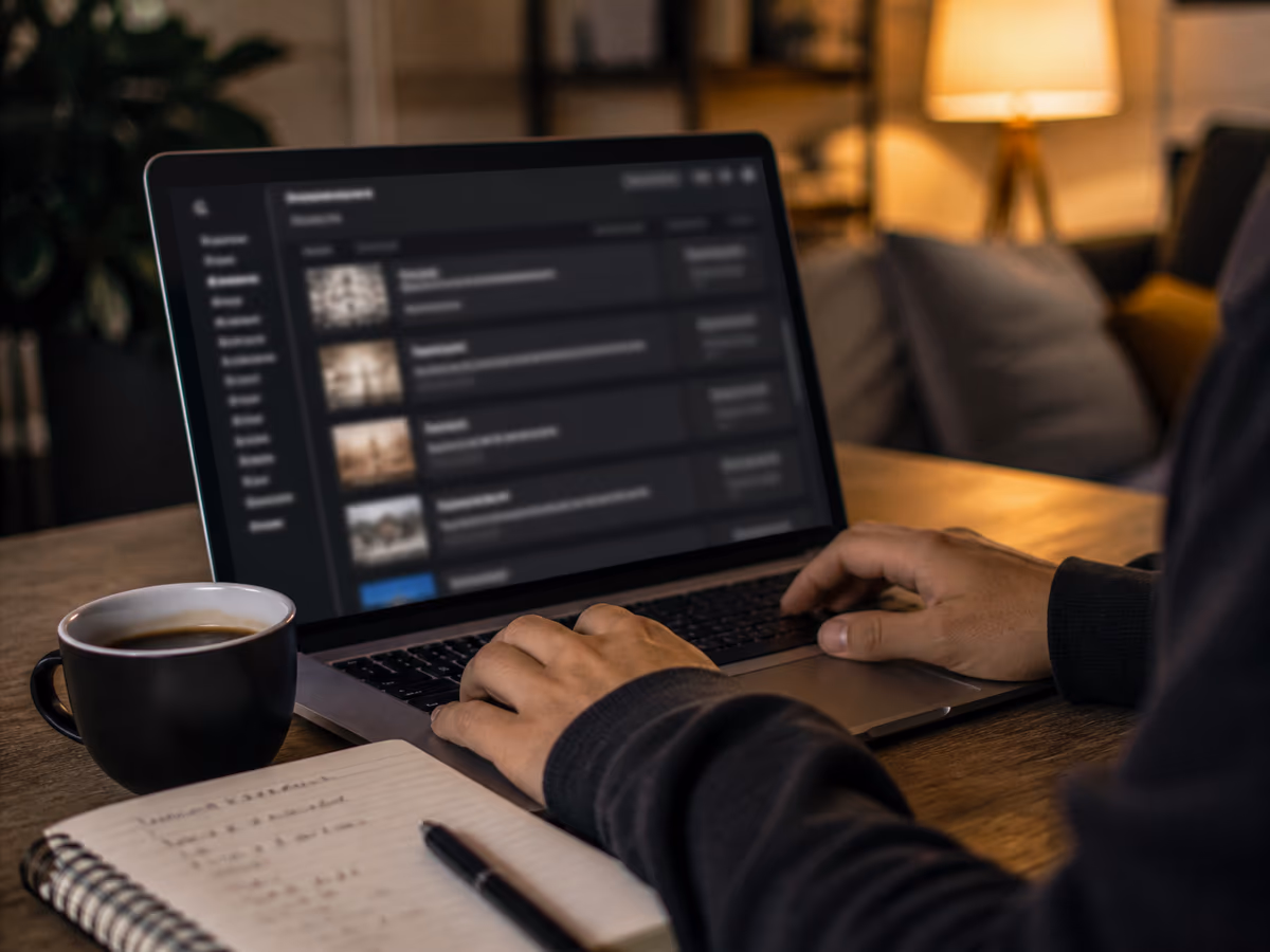 A user interacts with a laptop displaying dark web market listings in a cozy living room.